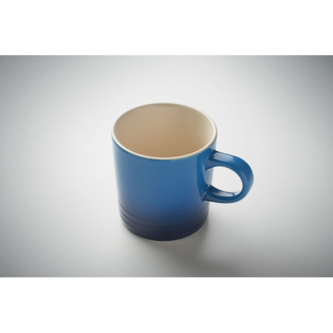 Mug en céramique bleu à personnaliser vu en plongée sur un bureau