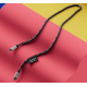 Câble USB-C noir personnalisé en Jacquard, posé en boucle sur fond rouge et jaune