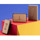 Batterie externe personnalisée Core posée sur un socle rouge et jaune, vue packaging