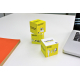Deux cubes jaunes posés verticalement près d’un carnet orange, avec marquage sur chaque face