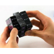 Rubik’s Cube noir manipulé, avec logos PlayStation et symboles colorés visibles