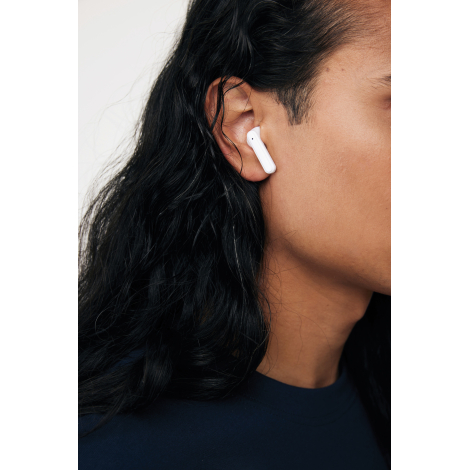 Personne portant un écouteur blanc sans fil à l’oreille, vue rapprochée.