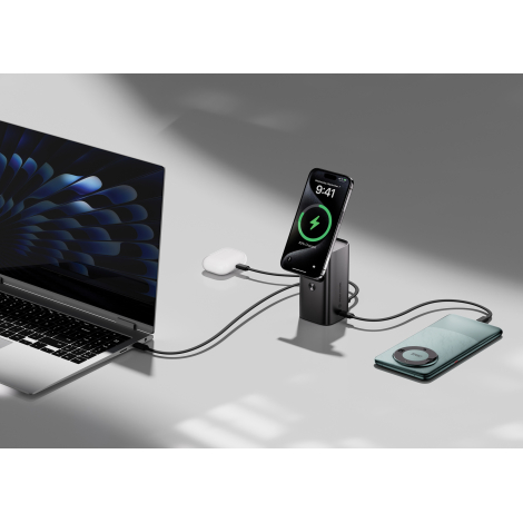 Batterie externe noire connectée à un ordinateur portable, smartphone et écouteurs