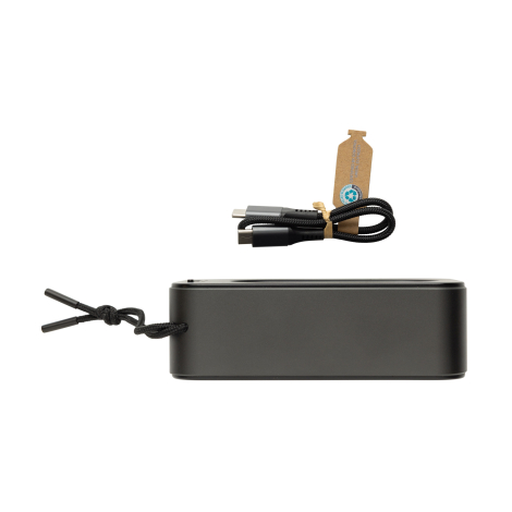 Vue latérale de l’enceinte noire avec lanière et câble de charge posé au-dessus
