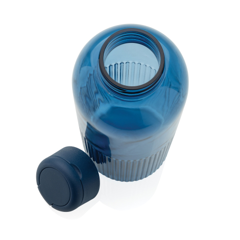 Bouteille bleue translucide ouverte avec bouchon bleu marine posé à côté