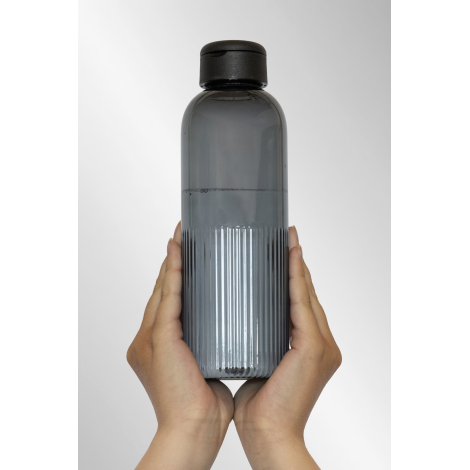 Bouteille grise translucide tenue à deux mains avec surface nervurée