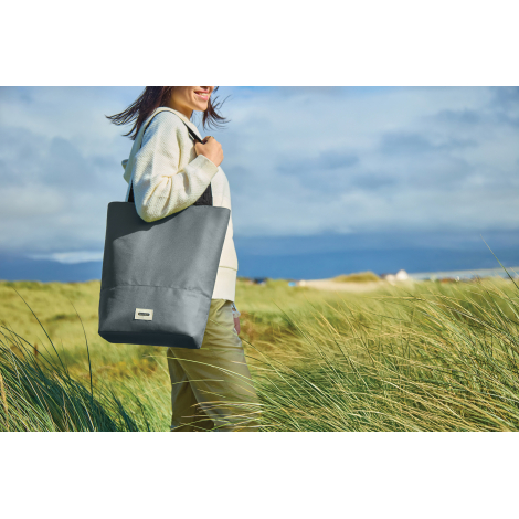 Sac isotherme gris porté à l’épaule en extérieur, sans personnalisation.