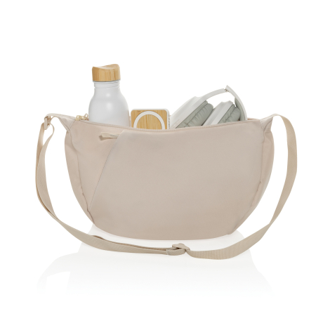 Sac bandoulière beige ouvert avec gourde, casque et enceinte visibles, sans personnalisation.
