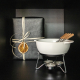 Set à fondue présenté dans un décor festif avec un cadeau emballé en arrière-plan, sans personnalisation.