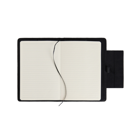Carnet de notes noir ouvert vu de dessus avec pages lignées, signet ruban et rabat latéral, sans marquage visible.