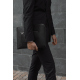 Sacoche ordinateur noire portée à la main par une personne en costume, poche zippée avant visible, sans marquage visible.