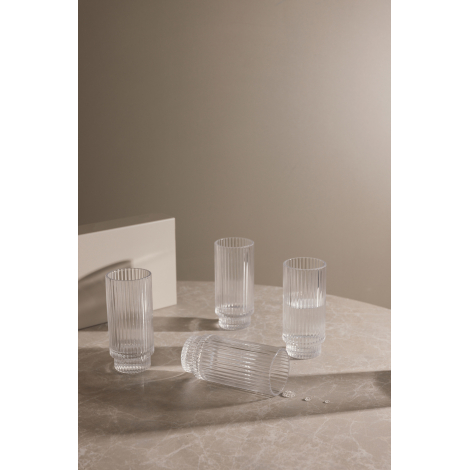 Ensemble de quatre verres rainurés sur table, dont deux partiellement remplis d’eau.