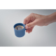 Tasse à expresso bleue remplie de café, tenue à la main en situation, sans marquage.