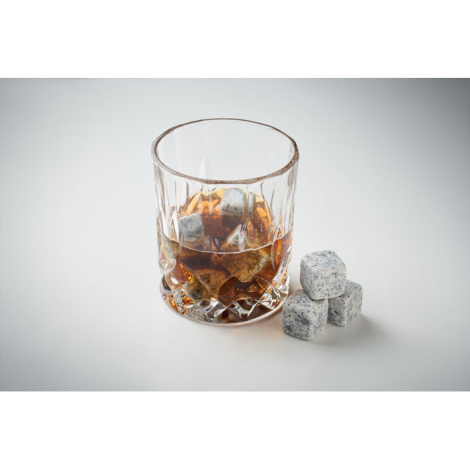 Verre à whisky transparent avec glaçons en pierre grise et trois glaçons posés à côté, sans marquage.