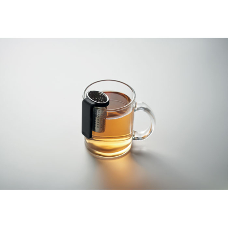 Infuseur à thé fixé sur une tasse en verre remplie de thé, sans personnalisation.