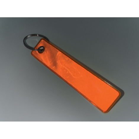 Porte-clés rectangulaire réfléchissant orange posé sur surface sombre, sans personnalisation.
