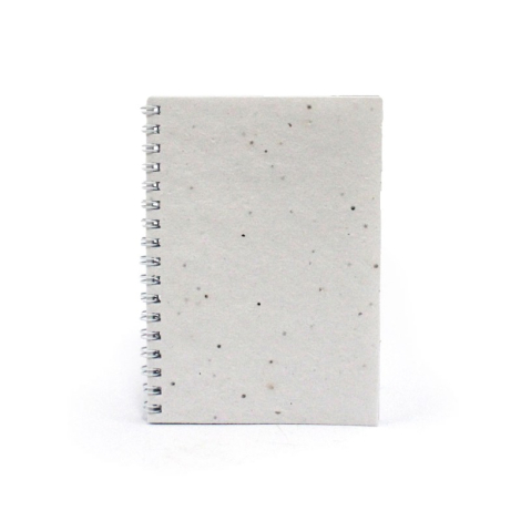 Carnet A6 en papier blanc à inclusions, reliure spirale sur le côté gauche, sans personnalisation visible.