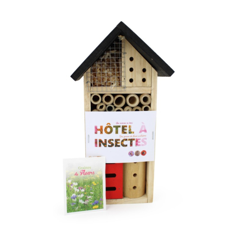 Hôtel à insectes en bois clair avec toit noir, compartiments variés, étiquette et graines visibles, marquage sur l’étiquette.