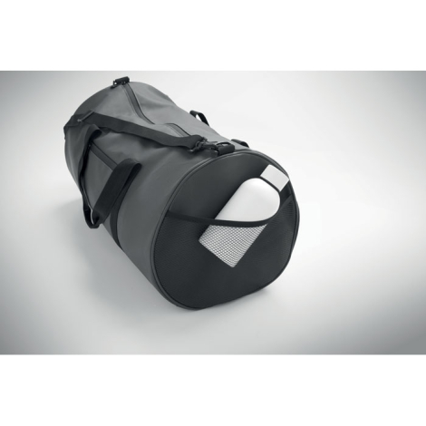 Sac de sport gris en polyester recyclé vu de côté avec gourde insérée dans la poche filet, sans marquage.