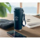 Gobelet isotherme bleu mat de 500 ml posé sur un bureau avec accessoires, marquage visible sur la face avant.