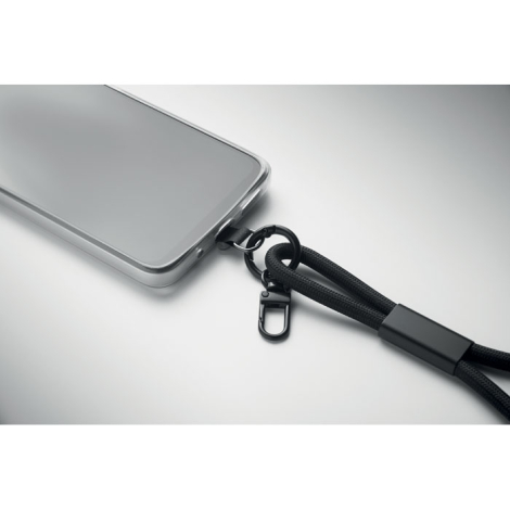 Gros plan sur la connexion entre le bracelet de chargement noir et un smartphone gris, sans personnalisation visible.
