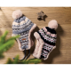 Deux bonnets en maille posés sur surface bois, marquage visible sur le cache-oreille de l’un des modèles.