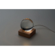 Lampe LED allumée dans une ambiance sombre, sphère en verre sur socle bois, sans personnalisation visible.