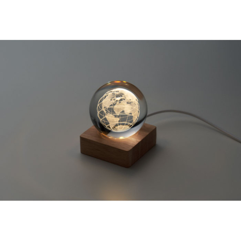 Globe LED allumé en ambiance sombre, socle en bois clair, sans personnalisation visible.