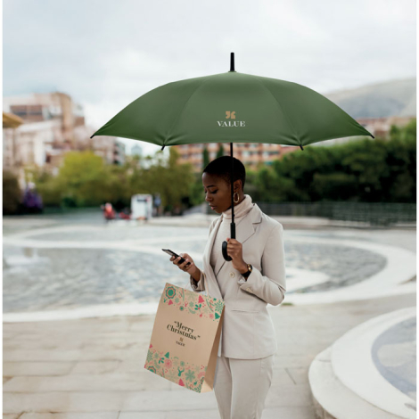 Parapluie vert de 23 pouces tenu en extérieur, marquage visible sur un pan de la toile.