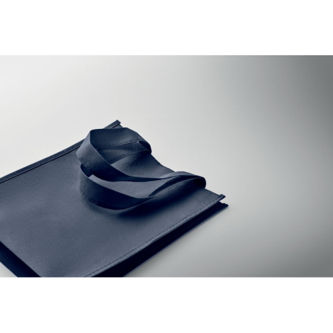 Sac cadeau bleu marine plié à plat avec anses repliées, sans personnalisation visible.