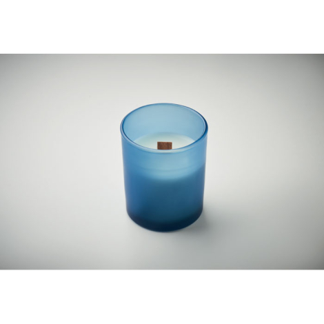 Bougie en cire végétale blanche dans un pot en verre bleu dépoli avec mèche en bois.