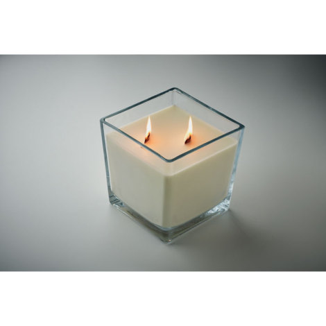 Bougie blanche en cire végétale allumée dans un pot carré en verre transparent avec deux mèches en bois.