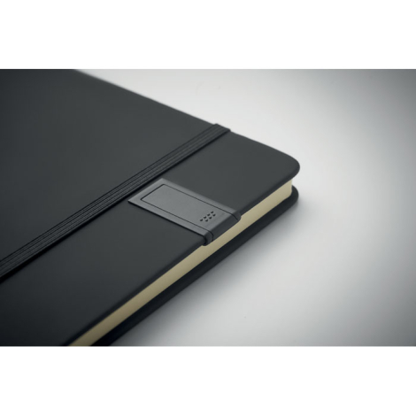 Gros plan sur un carnet A5 noir montrant le support latéral avec clé USB intégrée.