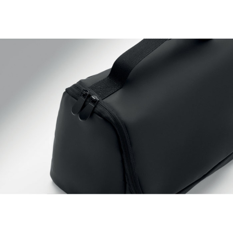 Pochette noire en PU vue de près avec fermetures éclair doubles et poignée supérieure.