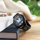 Montre connectée posée sur un livre, bracelet noir avec marquage visible sur le côté.