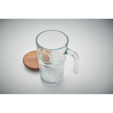 Mug en verre transparent vu du dessus avec couvercle en bois placé à côté.