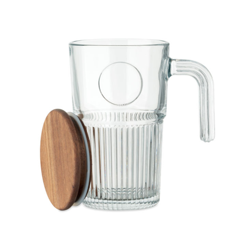 Mug en verre transparent avec couvercle en bois posé sur le côté.