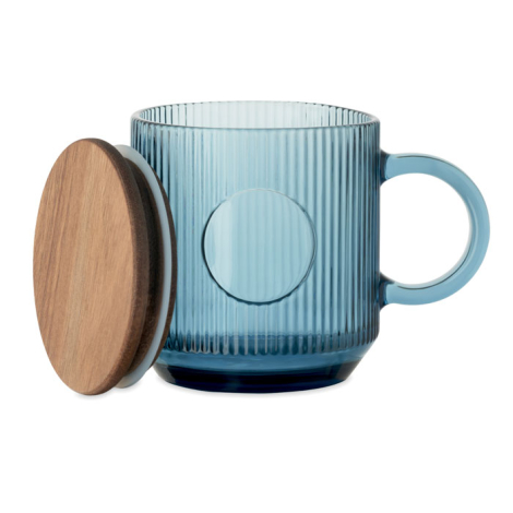 Mug en verre strié bleu avec couvercle en bois posé à côté.