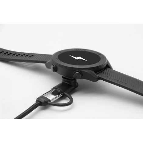 Gros plan d’un connecteur inséré dans une montre Garmin noire posée à plat, sans marquage visible.