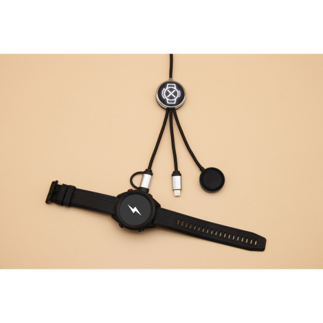 Câble avec module rond lumineux et montre connectée noire posée sur fond beige, marquage visible sur le module.
