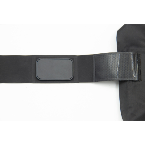 Gros plan sur une sangle noire avec zone rectangulaire rigide et bande à scratch transparente, sans marquage visible.
