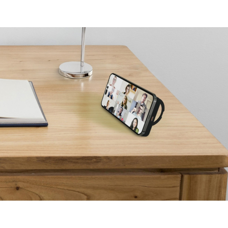 Smartphone posé horizontalement sur support circulaire intégré, affichant un appel vidéo en mosaïque, sans marquage visible.