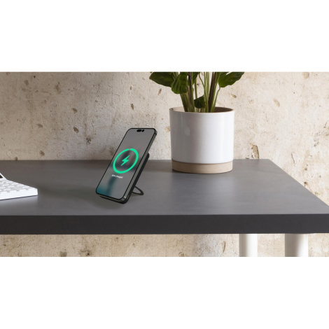 Smartphone placé verticalement sur support circulaire intégré affichant un écran de charge avec symbole vert, sans marquage visi