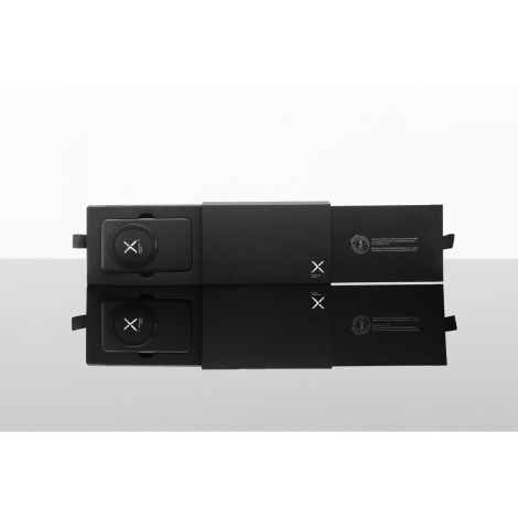 Coffret noir rectangulaire ouvert contenant la batterie externe avec anneau circulaire visible, sans marquage visible.