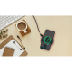 Smartphone posé sur chargeur circulaire noir branché, affichant écran de charge, posé sur bureau avec accessoires, sans marquage