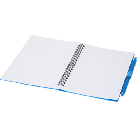 Carnet souple bleu ouvert à plat avec reliure spirale et stylo assorti fixé sur le côté.
