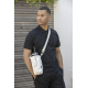 Homme portant un sac porte-bouteille beige en bandoulière avec gourde, sans marquage visible.