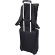 Vue arrière du sac fixé sur une valise via une sangle horizontale, sans marquage visible.