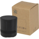 Enceinte noire cylindrique avec base plate et marquage visible au-dessus des boutons de commande, posée près de son emballage en