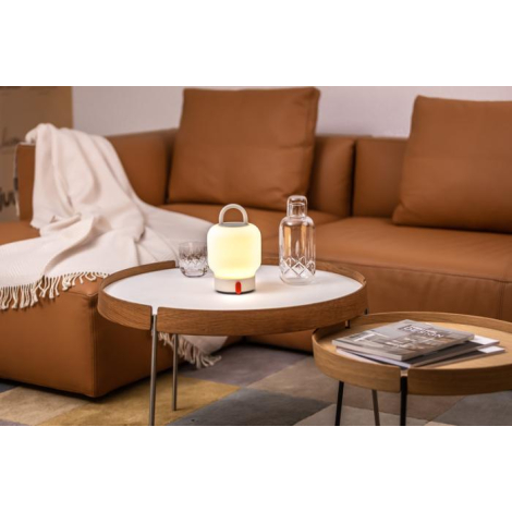 Lampe allumée sur table en bois clair entourée d’une carafe et d’un verre, sans marquage visible.